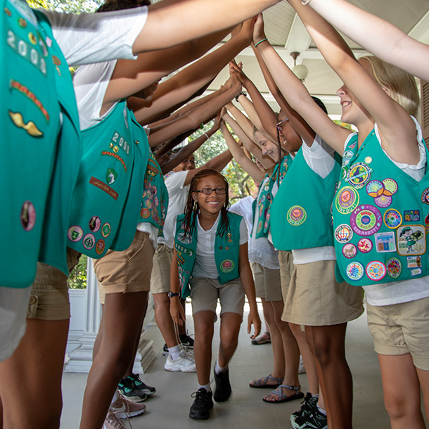 junior girl scouts walking through a hand bridge